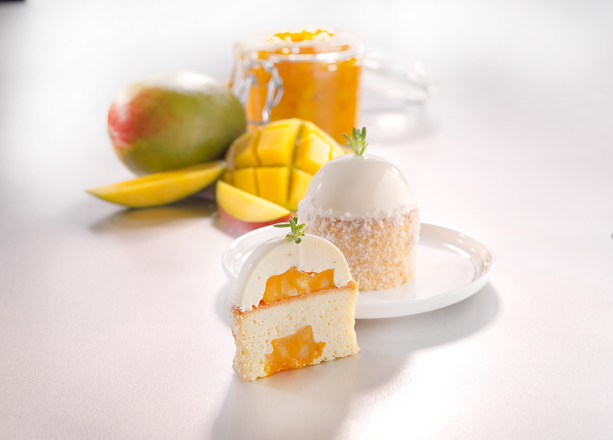 Photo d’un cake à la noix de coco, garni d’un fourrage à la mangue, avec des petits morceaux pour apporter de la texture.