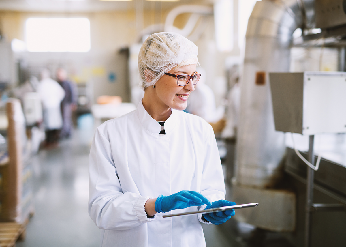 Photo d’une technicienne qualité en usine vérifiant la conformité des process et la sécurité des aliments afin d’éviter tout risque pour les clients et d’assurer une qualité irréprochable des produits.