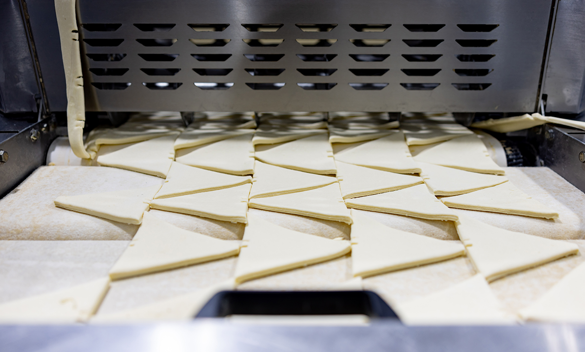 Photo d’une ligne de production de biscuits garnis de fourrage au fruit, montrant notre capacité à prendre en compte les contraintes de fabrication de nos clients dans le développement de produits à façon.