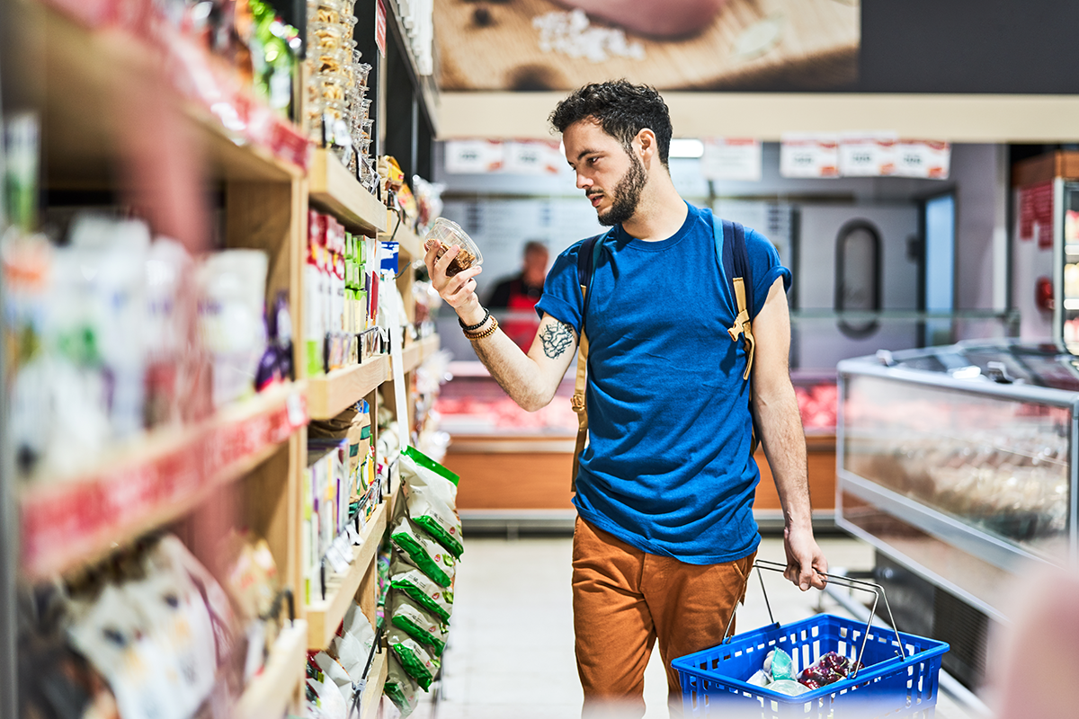 Photo d’une consommateur analysant l’étiquetage d’un produit afin de visualiser le nutri-score et de guider sa décision d’achat. 