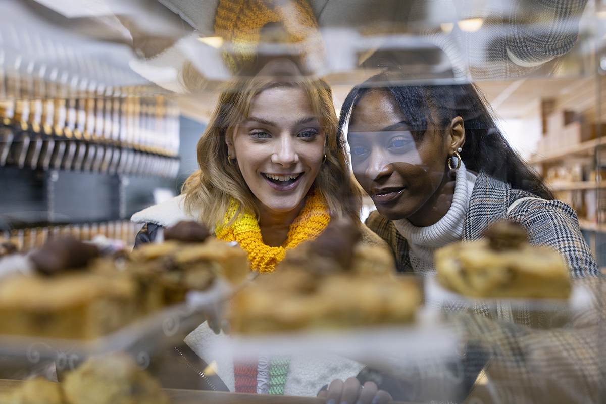 Photo de deux consommatrice regardant une vitrine de pâtisserie, à la recherche d’un dessert moins sucré et pour autant donnant autant de plaisir gustatif.