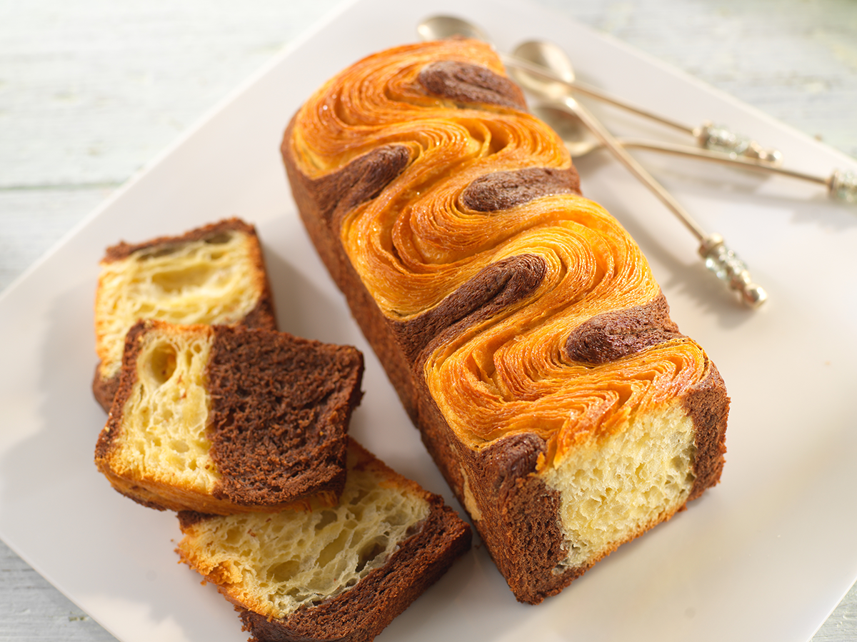 Photo d’une brioche marbrée, chocolat et vanille, réalisée avec une pâte à croissant pour un aspect feuilleté et une texture croustillante.