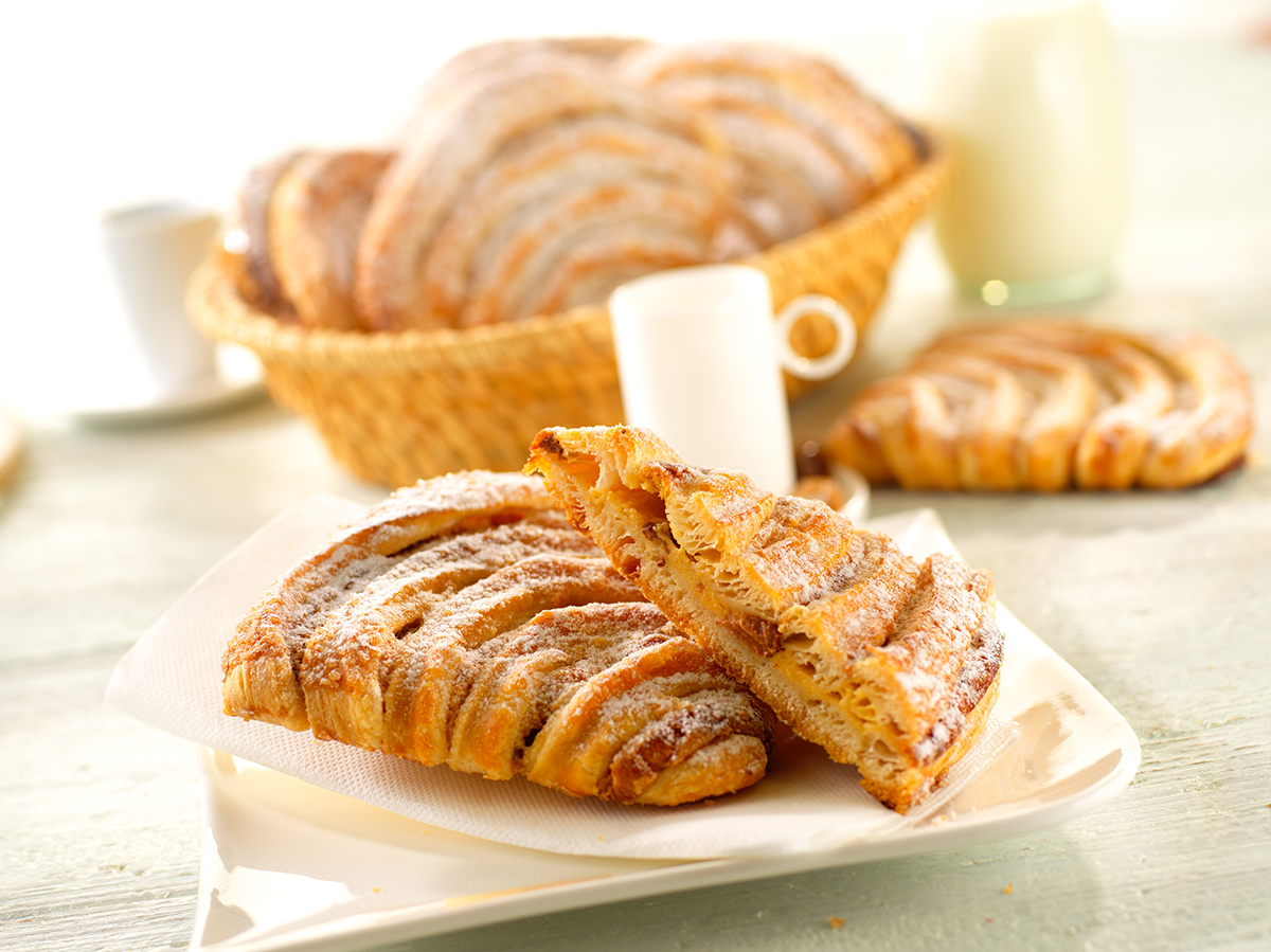 Photo d’un chausson réalisé avec une pâte feuilletée viennoise et fourré avec une garniture à la napolitaine, composée de crème pâtissière et de raisins secs.