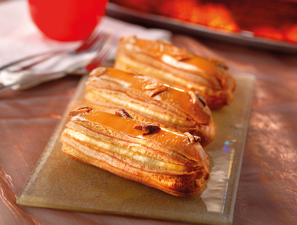 Photo d’éclairs à la crème pâtissière aromatisée au caramel et glacés de fondant caramel.