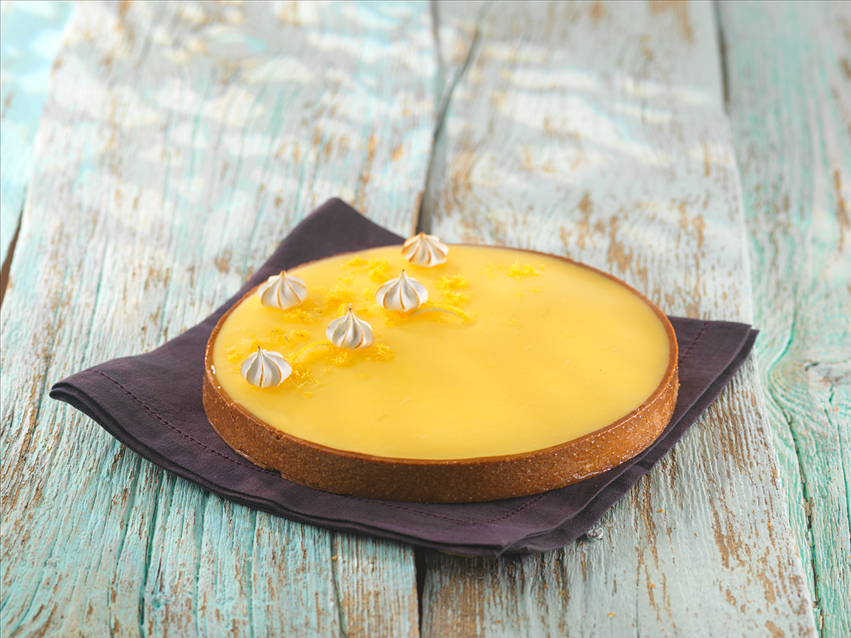Photo d’une tarte au citron au fourrage citron généreux et onctueux avec de petites meringuettes sur le dessus.