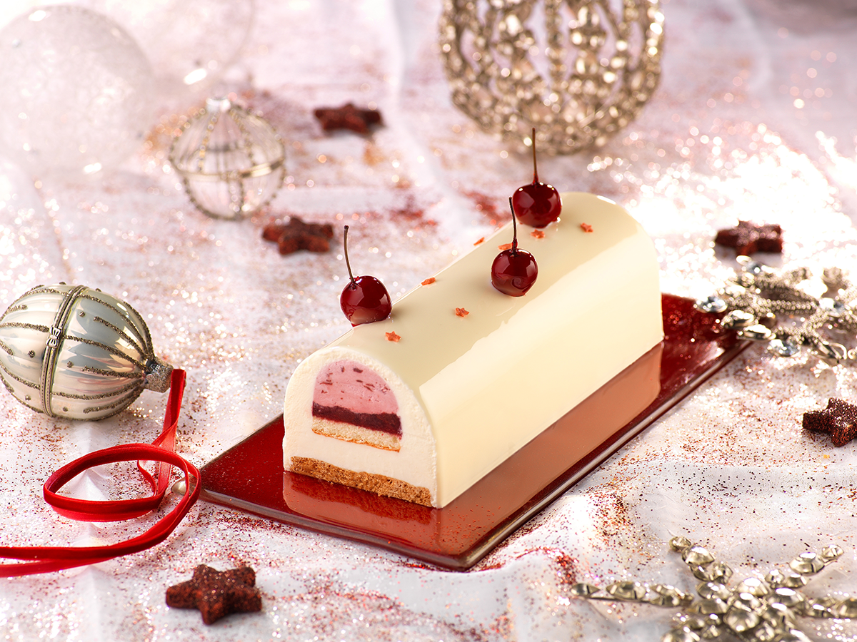 Photo d’une bûche de Noël à la cerise, donc la compotée et la mousse ont été réalisées avec un fourrage à la cerise noire. 