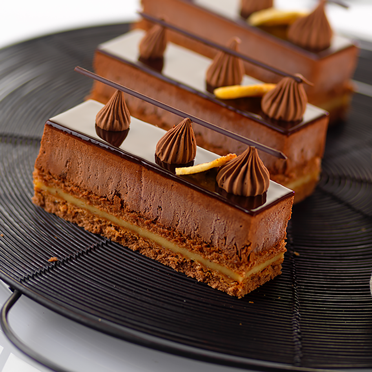 Photo d’un insert gélifié tendre à la banane en fine couche, d’une épaisseur d’un centimètre pour apporter de la douceur et du crémeux à l’entremets au chocolat noir.