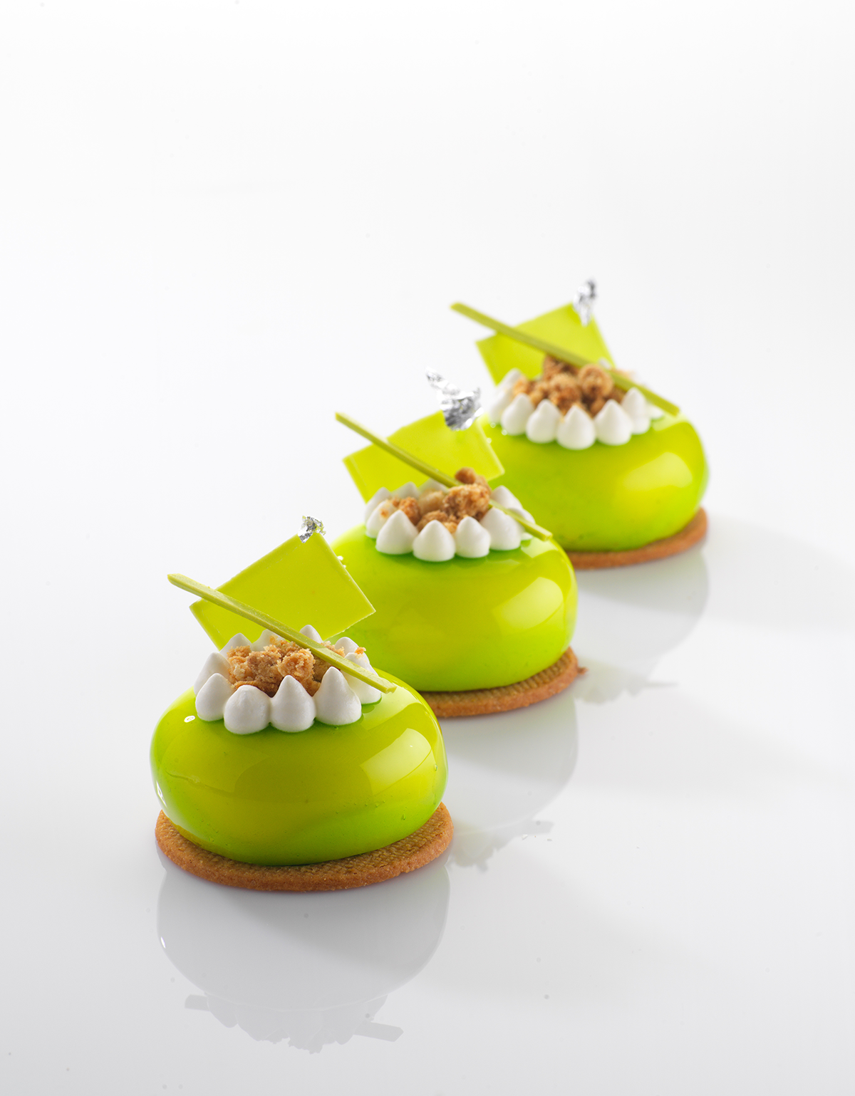 Photo d’entremets individuels glaçés de miroir neutre coloré en vert et symbolisant notre expertise pour répondre à toutes les problématiques des industriels pour nettoyer les formules de leurs produits finis en les rendant plus Clean Label.